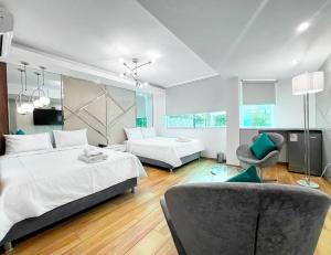 a large bedroom with two beds and a chair at Wyka Hotel in Trujillo