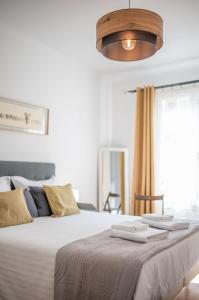 a bedroom with a large bed with two towels on it at Le COQ Edouard VII - Parking - Proche mer in Menton