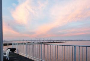 a balcony with a view of a marina at sunset at LUX IN THE AIR - An Elevated Experience on the Vaal Dam in Denysville
