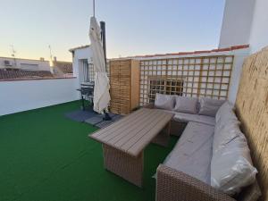 a patio with a couch and a table on a roof at Casa Caldereta in Ayelo de Rugat