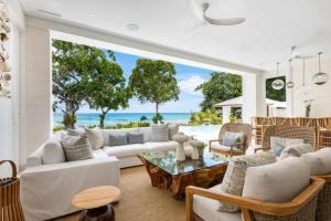 セント・ジェームスにあるVilla Prestige Barbadosの白い家具付きのリビングルームが備わり、海の景色を望めます。