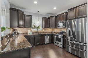 una cucina con armadietti in legno ed elettrodomestici in acciaio inossidabile di 137 Golf Villa Dr - Villa Coastalotta a Santa Rosa Beach Altre 37 foto