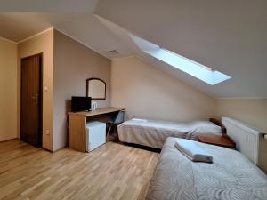 a small room with two beds and a skylight at Aparthotel Xavito in Sanok