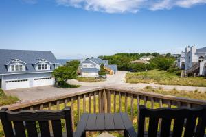 Jay CrestにあるNewly Listing Renovated bungalow steps from waterのテーブルと椅子付きの家のバルコニーから景色を望めます。