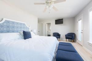 Jay CrestにあるNewly Listing Renovated bungalow steps from waterのベッドルーム(青いヘッドボード付きの白い大型ベッド1台付)