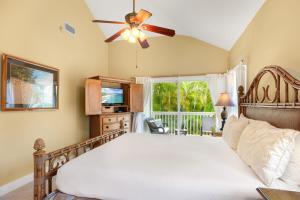 a bedroom with a bed and a ceiling fan at Regency 620 in Koloa +44 photos
