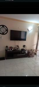 a living room with a large flat screen tv on the wall at Nyali BnB Apartment in Mombasa