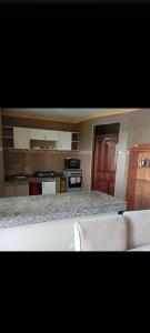 a kitchen with a counter and two white chairs at Nyali BnB Apartment in Mombasa