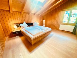 a bedroom with a bed in a room with wooden walls at Chalet with Scenic Valley & Mountain Views in Lütschental