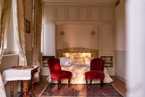 a bedroom with a bed and two red chairs at Marica in Pesaro
