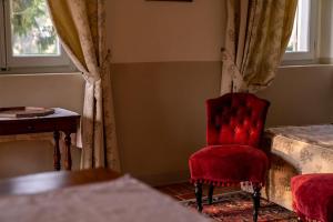 a room with a red chair and a table and window at Marica in Pesaro +31 photos