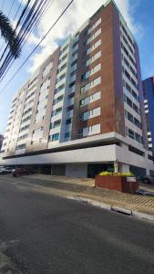 a large building on the side of a street at Apartamento Aconchegante e completo em Manaíra in João Pessoa