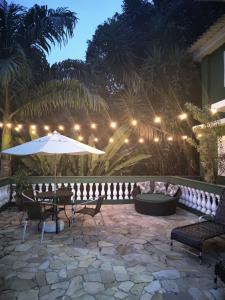 a patio with a table and an umbrella at night at Cobertura na Enseada a 80 m da areia in Ubatuba
