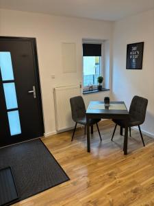 a dining room with a table and chairs and a door at Ferienwohnung am Engelmannsberg in Hattenheim