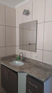 a bathroom counter with a sink and a mirror at Cobertura na Enseada a 80 m da areia in Ubatuba