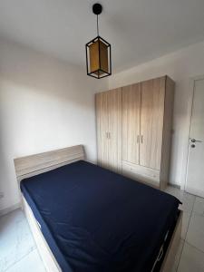a bedroom with a blue bed and a chandelier at Tedds Cosy 2 bedroom Apartment in Tal-Pietà