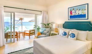a bedroom with a bed and a view of the ocean at The Inn at English Harbour in English Harbour Town +42 photos