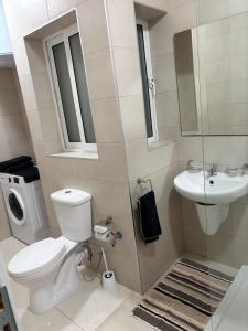 a bathroom with a toilet and a sink at Tedds Cosy 2 bedroom Apartment in Tal-Pietà