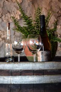 two glasses of wine and a bottle on a table at Téged Vártunk Vendégház in Bakonyoszlop