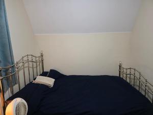 1 cama con manta azul y ventilador en Stay Near Colchester twn centre5, en Hythe