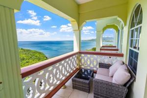 a balcony with a couch and a view of the ocean at Oceanview• Mins to the Beach•Private BR Balconies in Moule à Chique