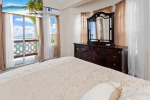 a bedroom with a bed and a mirror and a window at Oceanview• Mins to the Beach•Private BR Balconies in Moule à Chique