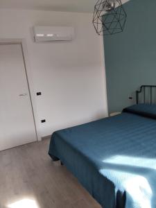 a bedroom with a blue bed and a white wall at Home 56 vacation home in Salerno