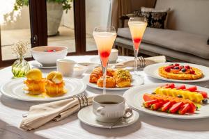 a table with plates of food and two glasses of drinks at Bastión Luxury Hotel in Cartagena de Indias