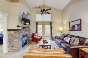 a living room with a leather couch and a fireplace at Base Camp One 403 in Granby