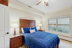 a bedroom with a blue bed and a window at Base Camp One 403 in Granby +54 photos