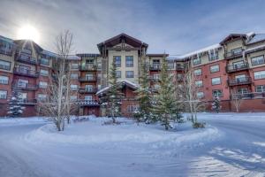a large apartment building with snow in front of it at Base Camp One 403 in Granby