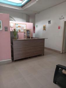 パルミラにあるHotel Pelmanのピンクと白の壁の部屋にある受付デスク