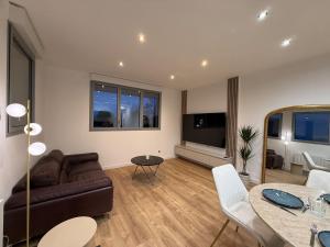 ein Wohnzimmer mit Sofa und Tisch in der Unterkunft T2 neuf marbre et or - écran géant - Netflix in LʼHermitage