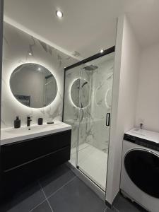 ein Badezimmer mit Dusche, Waschbecken und Spiegel in der Unterkunft T2 neuf marbre et or - écran géant - Netflix in LʼHermitage + 4 Fotos