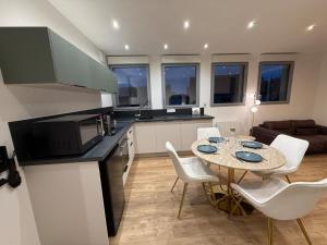 eine Küche und ein Esszimmer mit Tisch und Stühlen in der Unterkunft T2 neuf marbre et or - écran géant - Netflix in LʼHermitage