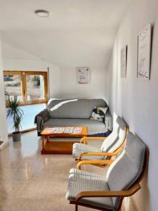 a living room with a couch and two chairs at Apartamento Espert l CINE l garaje l BBQ I Tenis in Biescas