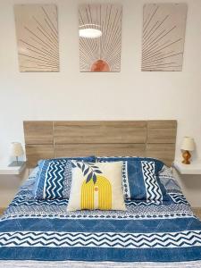 a bed with blue and white pillows on it at Apartamento Espert l CINE l garaje l BBQ I Tenis in Biescas