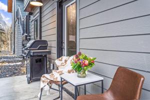 Un patio con mesa y sillas y una estufa. en Spacious 3BR Haven in Scenic Canmore, en Canmore