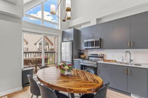 cocina con mesa y mesa de madera con sillas en New 3BR with Mountain Views Near DT Hot Tub and Pool, en Canmore
