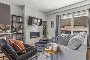 una sala de estar con un sofá y una chimenea en New 3BR with Mountain Views Near DT Hot Tub and Pool, en Canmore