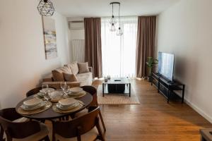 ein Wohnzimmer mit Tisch und Couch in der Unterkunft Planet Gemini Residence in Niš