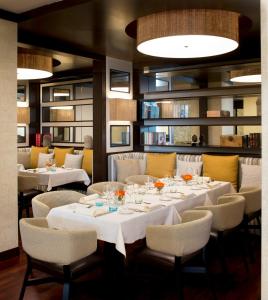 ボローニャにあるスターホテルズ エクセルシオールの白いテーブルと椅子のあるダイニングルーム