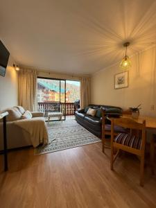 a living room with a couch and a table at Nevados de chillan , edificio los coigues in Nevados de Chillan +23 photos