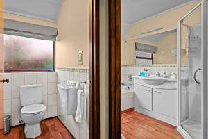 ein Badezimmer mit Toilette und Waschbecken in der Unterkunft Tranquil West Haven with Water and Skyline Views in Auckland + 28 Fotos