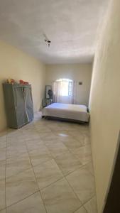 a bedroom with a bed and a tiled floor at Espaço de Iguaba Grande in Iguaba Grande