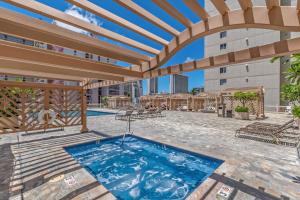 an outdoor patio with a swimming pool and a pergola at Two Amazing Views in One Spacious Condo Getaway in Honolulu