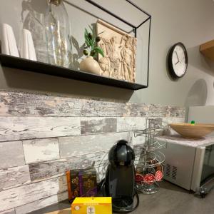 Una cocina con una pared de azulejos y una tetera sobre la encimera. en Charming apartment with two bedroms and beautifull sea view in Fauske, en Fauske