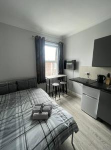 a bedroom with a bed and a kitchen with a table at The Oxford Avenue in Southampton