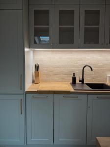 a kitchen with white cabinets and a sink at Apartamenty Guzik 31 in Krosno +13 photos