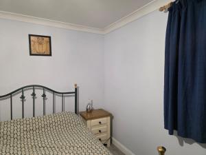 a bedroom with a bed and a blue curtain at Stay Near Colchester twn centre2 in Hythe